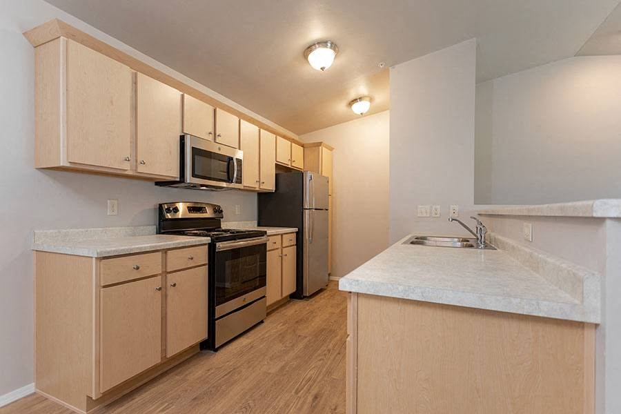 an empty kitchen with a stove and a refrigerator