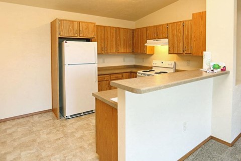a kitchen with a white refrigerator and a counter