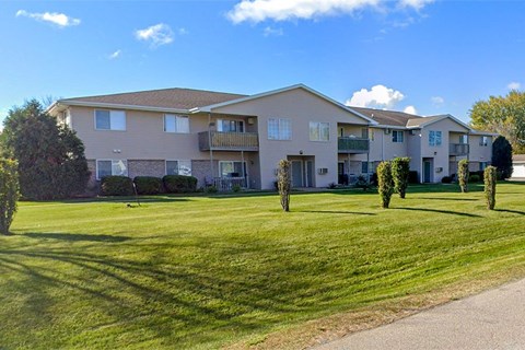 Apartment complex with green lawn in front.