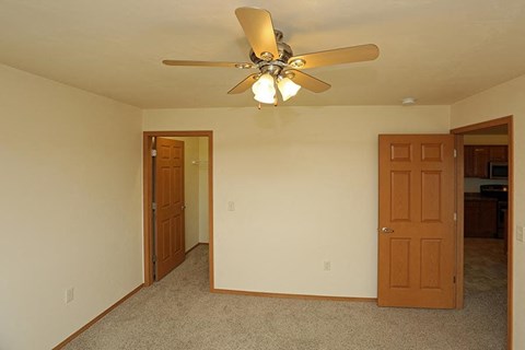 a living room with a ceiling fan and a door