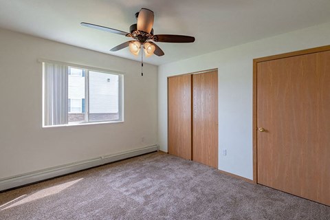 an empty room with a ceiling fan and a closet