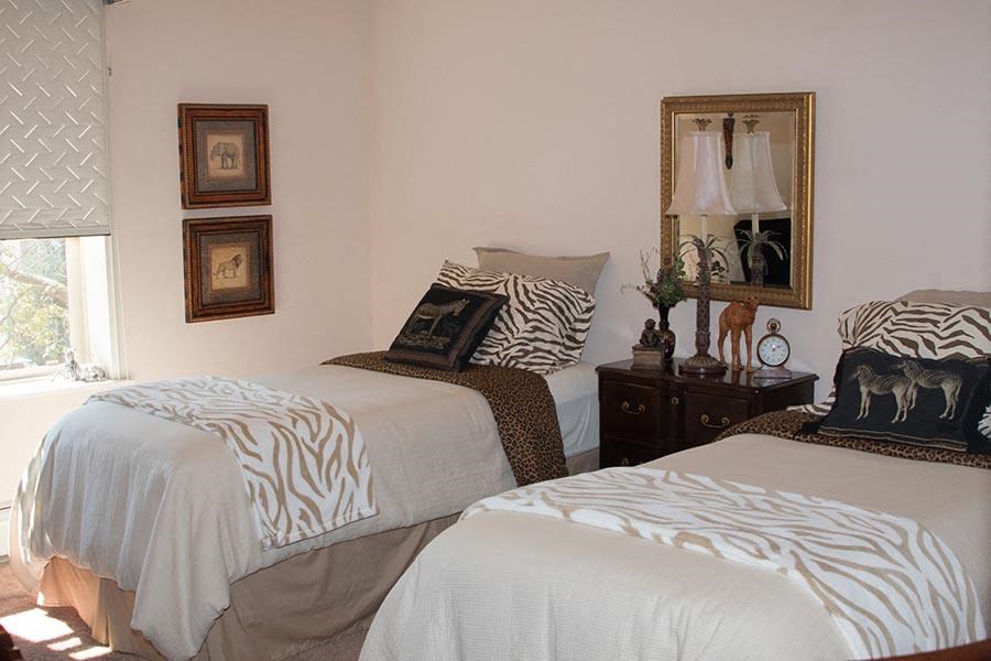 a bedroom with two beds with zebras on them