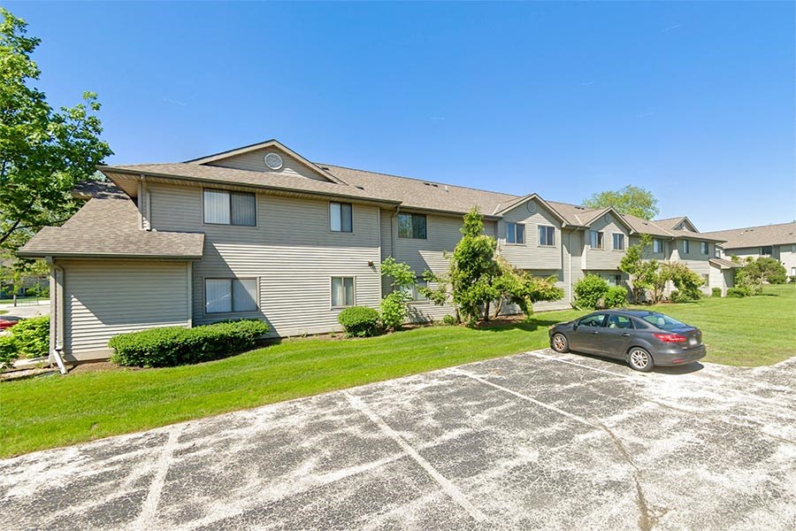a car parked in a parking lot in front of an apartment building