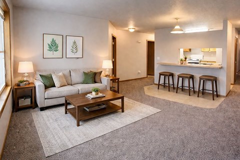 A living room with a couch, coffee table, and bar stools.