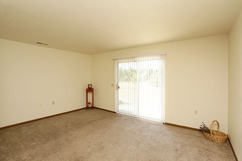 an empty living room with a sliding glass door