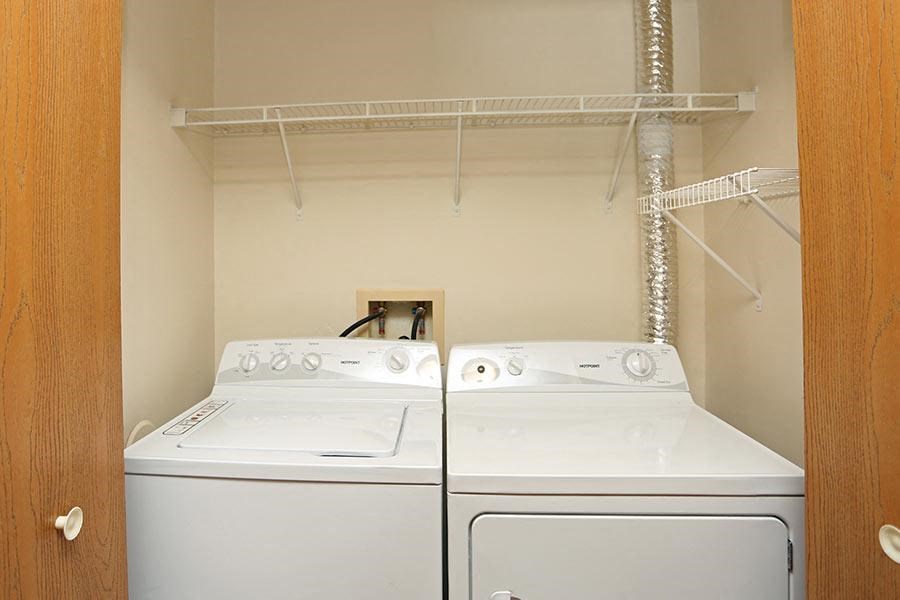 two white washers and dryers in a laundry room