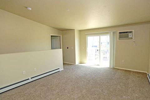 an empty living room with a door to a balcony