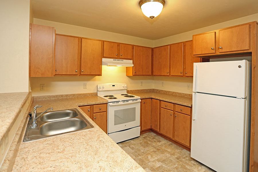 a kitchen with a stove refrigerator and a sink