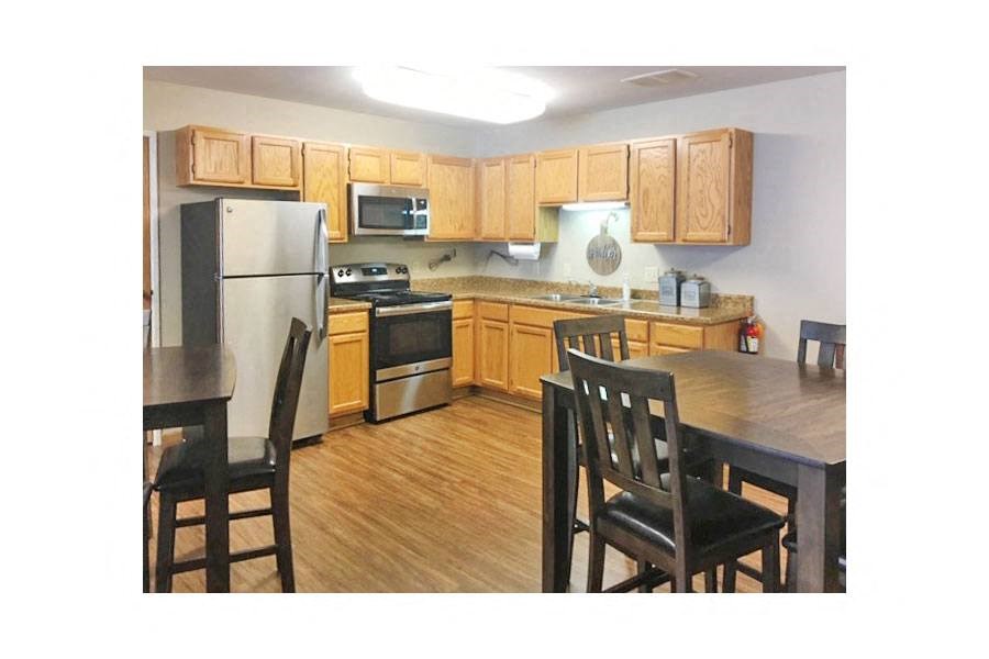 a kitchen with wooden cabinets and a table and chairs