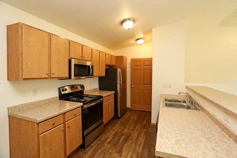 a kitchen with a stove refrigerator and a sink