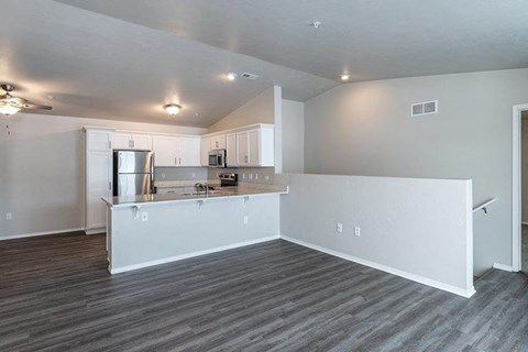 an empty living room with a kitchen and