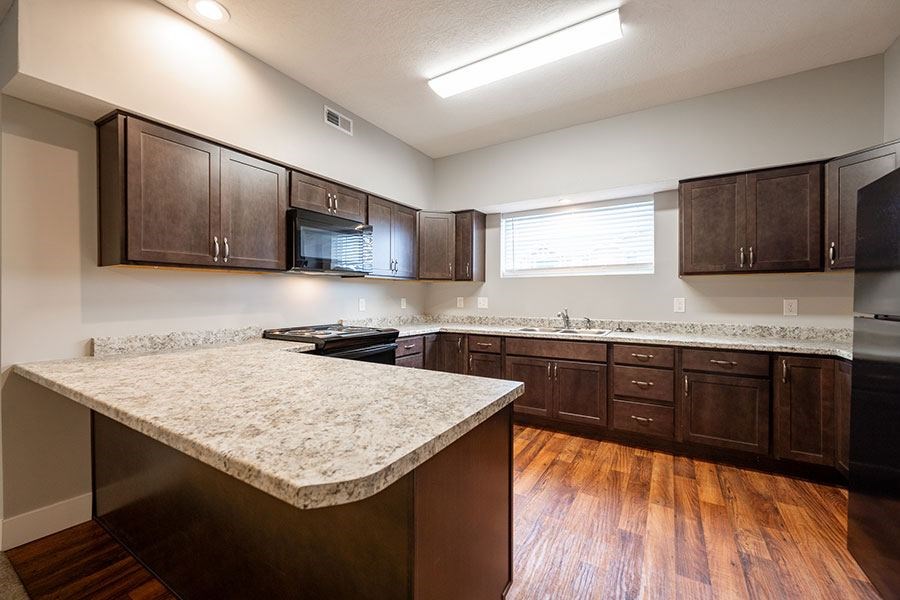 A kitchen with brown cabinets and a granite countertop.