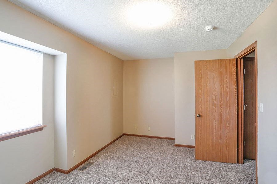 an empty room with a door and a window