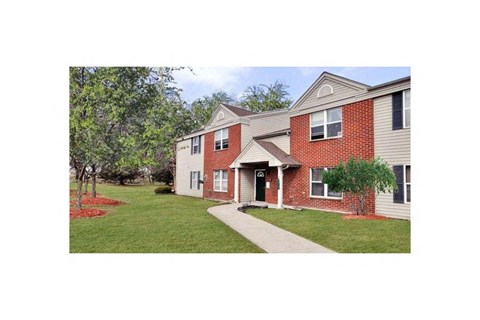 A red brick house with a white door and windows.
