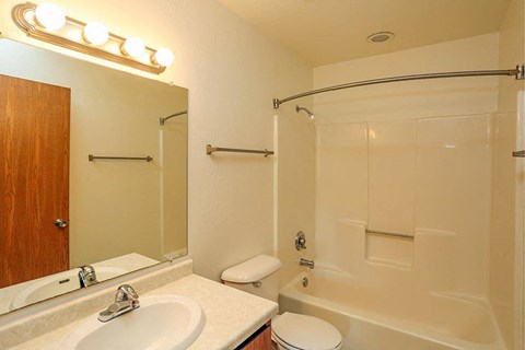 A bathroom with a white sink, toilet, and bathtub.