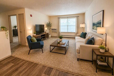 A living room with a blue chair, a white couch, and a coffee table.