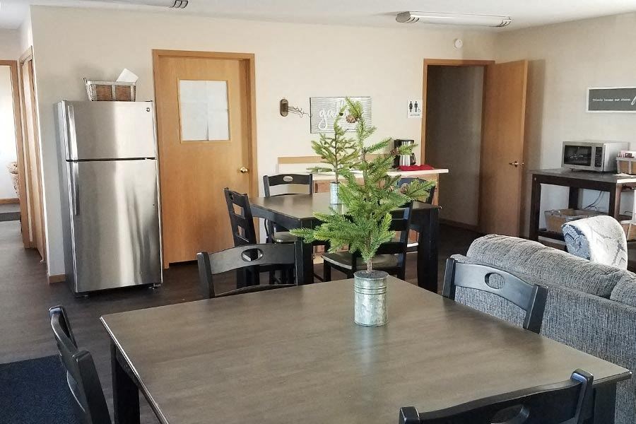 A dining room with a table, chairs, and a potted plant.