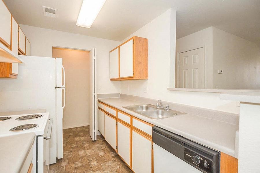 A kitchen with white appliances and wooden cabinets.