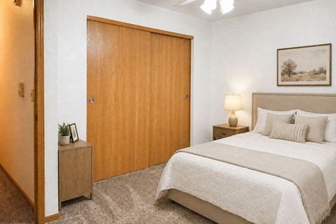 A bedroom with a large bed and a wooden door.