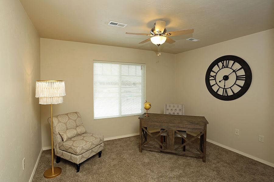 a living room with a chair and a clock on the wall