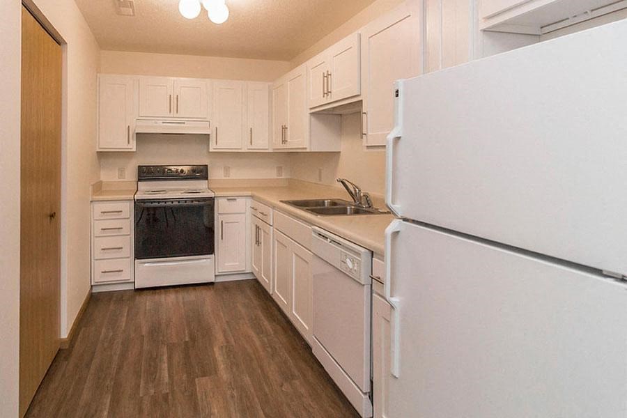 a white kitchen with a stove and a refrigerator
