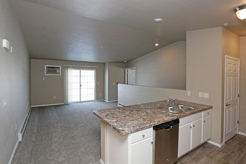 an empty kitchen with a granite counter top