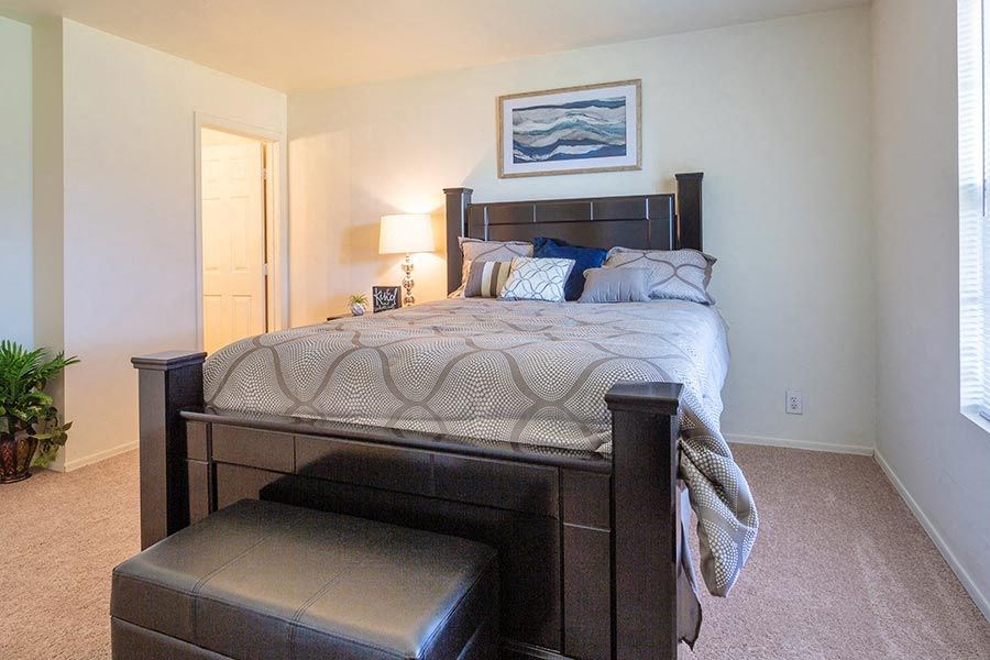 a bedroom with a bed and a stool