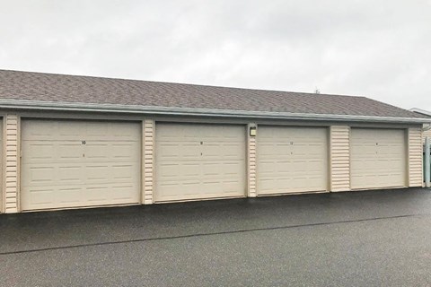 a row of white garage doors on the side of a building