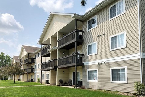 a building with two balconies and a lawn