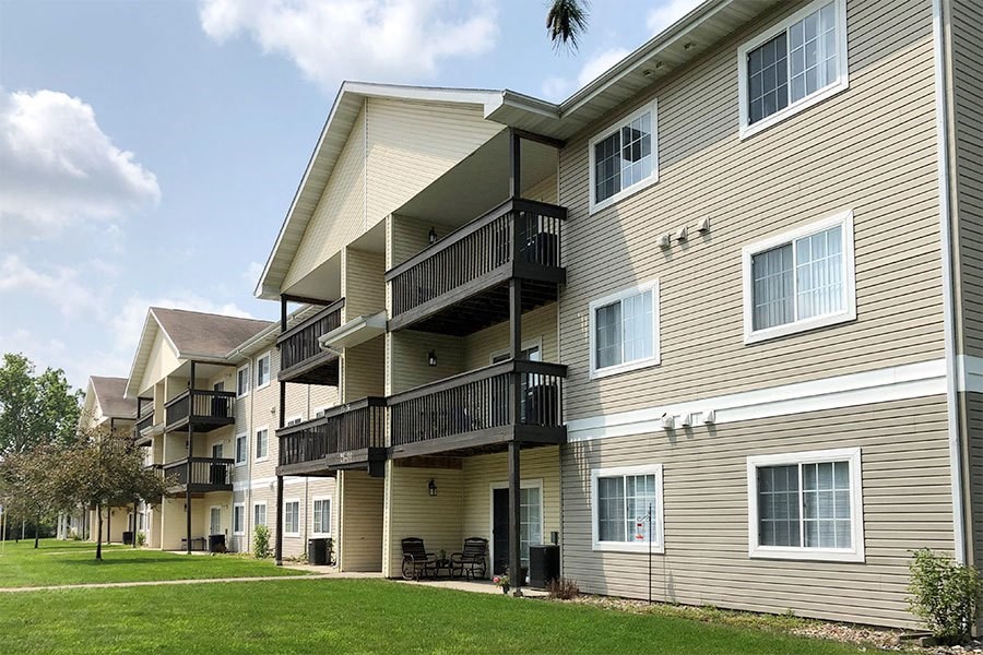 a building with two balconies and a lawn