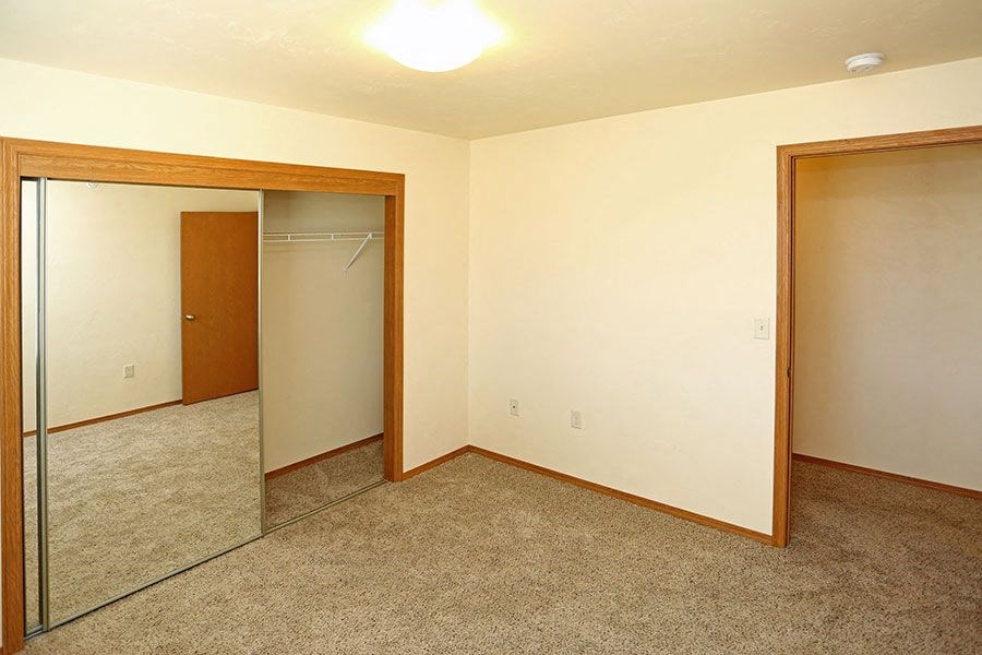 an empty room with a mirror and a closet