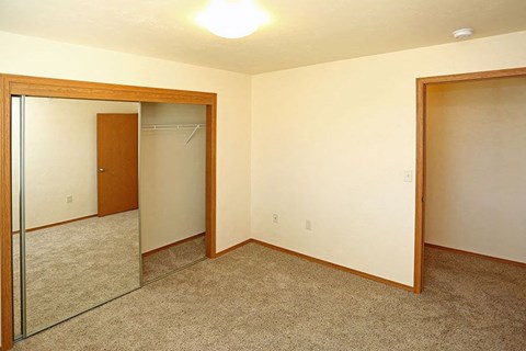 an empty room with a mirror and a closet