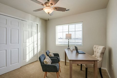a living room with a desk with a laptop