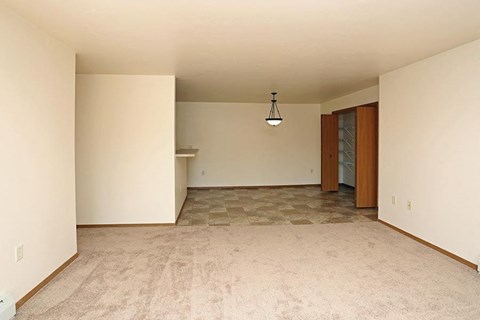 an empty living room with white walls and a tile floor