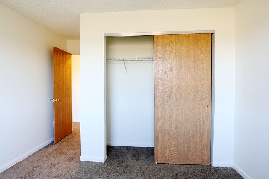 an empty closet in a room with a door