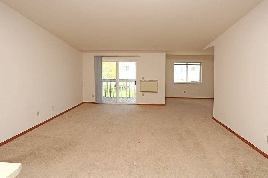 an empty living room with a door to a balcony
