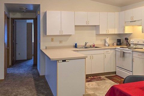 A kitchen with white cabinets and appliances.