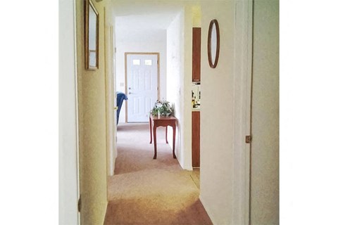 a hallway with a table and a white door