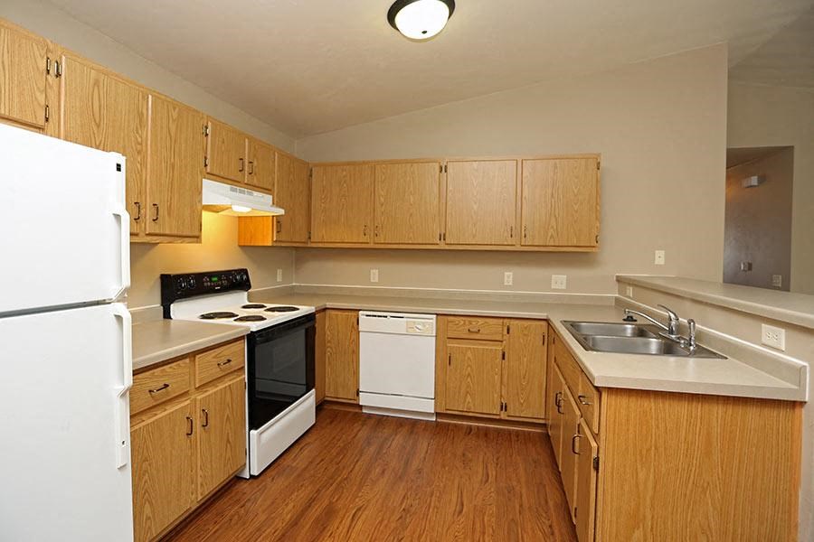 a kitchen with wooden cabinets and a stove and a refrigerator