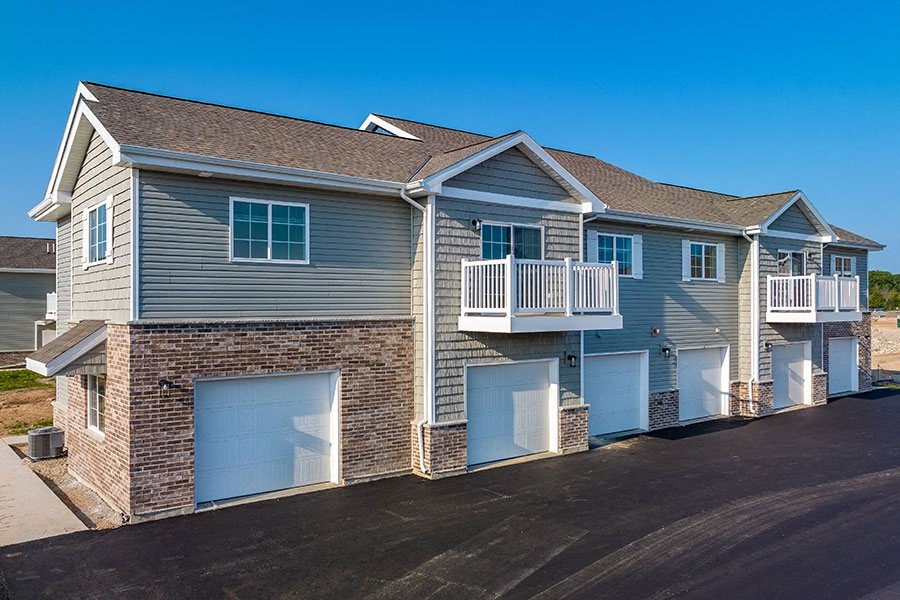 a blue house with blue garage doors and a balcony