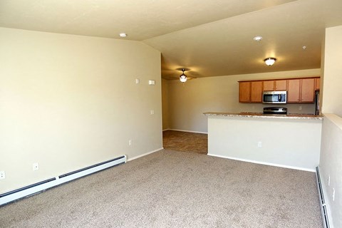 an empty room with a kitchen and a microwave