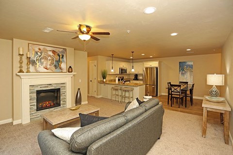 A living room with a grey couch and a fireplace.