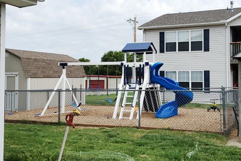 A playground with a blue slide and a white and blue tower.