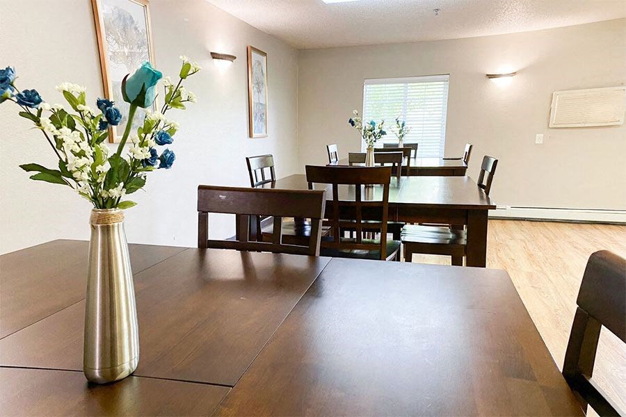 a dining room table with a vase of flowers on it