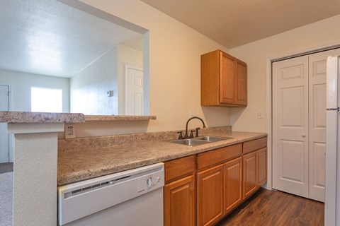 A kitchen with wooden cabinets and a granite countertop.