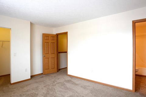 an empty room with a door and a closet