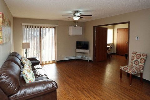 A living room with a brown leather couch and a television.