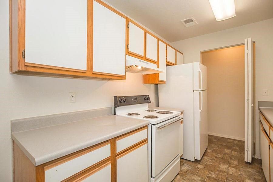 A kitchen with a white stove and white refrigerator.