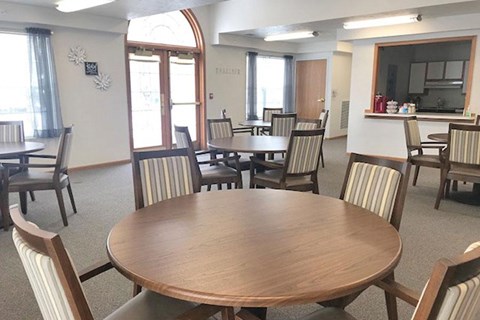 A dining room with a large table surrounded by chairs.