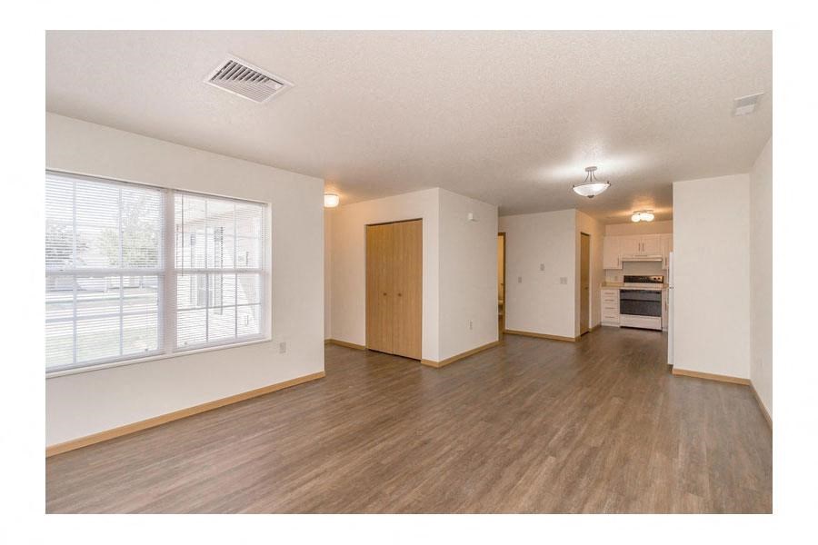 an empty living room with white walls and a large window